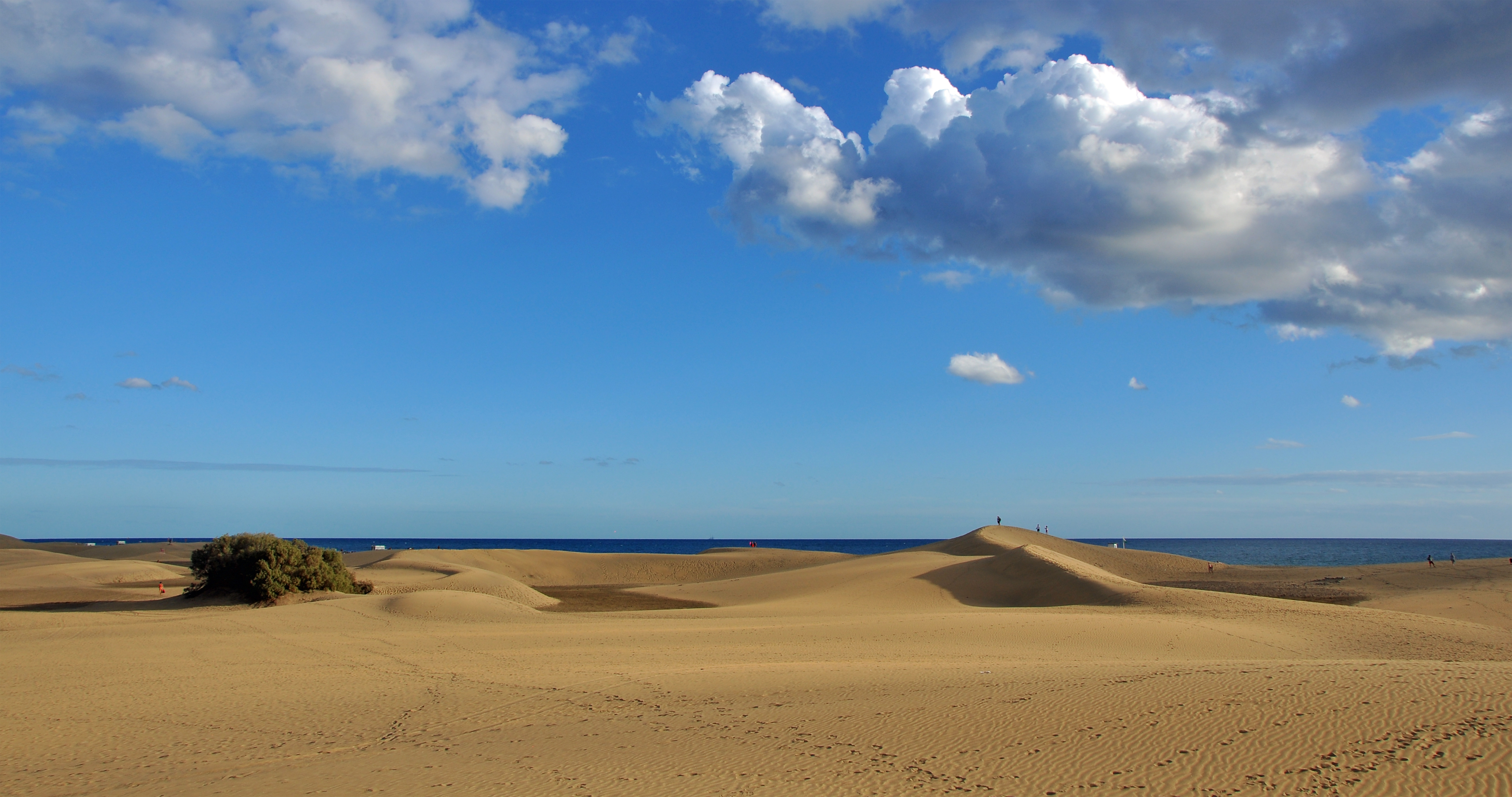 Dunas de arena dorada de Maspalomas bajo un cielo azul con nubes, Gran Canaria